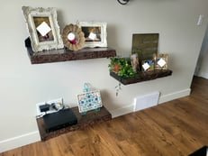 Modern living room with blue sofa, fireplace and floating shelves - handyman project